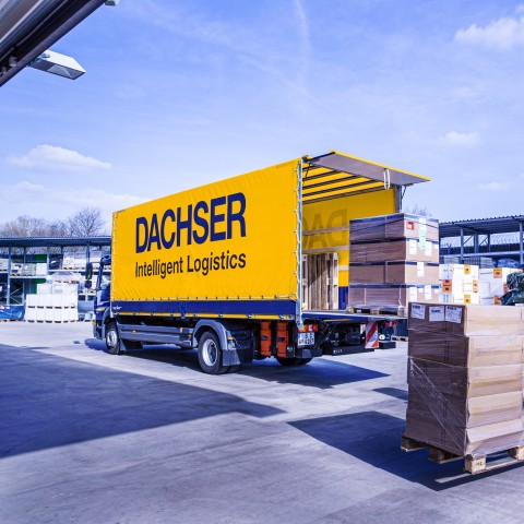DACHSER truck being loaded with palletised goods by a forklift at a logistics facility