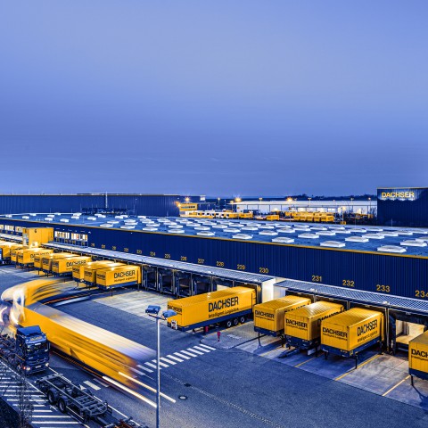 DACHSER logistics facility with trucks and trailers at multiple loading docks